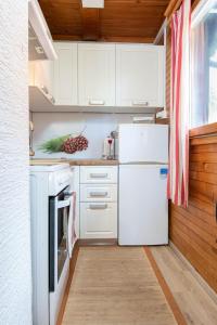 a kitchen with white cabinets and a white refrigerator at Cabin Storzek in Pohorje