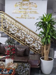 eine goldene Treppe mit Couch und Pflanze in der Unterkunft Hoàng Gia Hotel Royal 