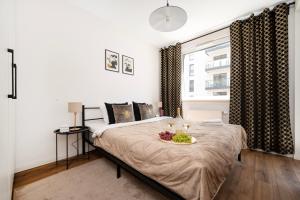 sypialnia z łóżkiem, na którym stoi miska z owocami w obiekcie Lumina cozy apartments Manufaktura w Łodzi