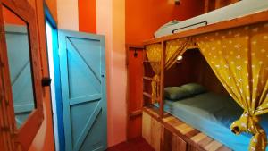a bedroom with a bunk bed and a door at INDIGO Motel in Karimunjawa