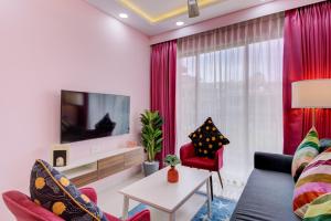 Televiisor ja/või meelelahutuskeskus majutusasutuses Luxe 2BHK 10min from GOI airport with Pool access