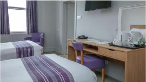 a hotel room with a desk and two beds at Tor Park Hotel, Sure Hotel Collection by Best Western in Torquay