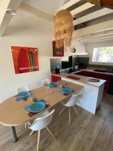 a kitchen with a wooden table and a dining room at Villa Dreamland à Seignosse océan in Seignosse