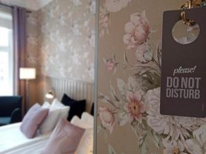 a bedroom with a bed and a sign on a wall at Hotell Linnéa - Helsingborg in Helsingborg
