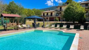 uma piscina com cadeiras e um gazebo em La Sorgente del Subasio Apartments em Assis