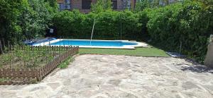 a swimming pool in a yard next to a fence at La Higuera de Gredos in Higuera de las Dueñas
