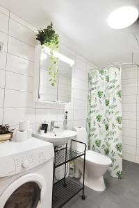 La salle de bains est pourvue de toilettes, d'un lavabo et d'un lave-linge. dans l'établissement Flamingo Modern Studio near Airport w FREE Parking, à Vantaa