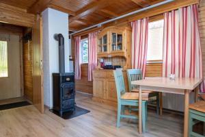 a kitchen and dining room with a wood stove at Cabin Storzek in Pohorje