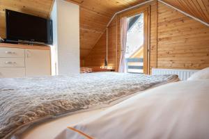 a bedroom with a bed and a large window at Cabin Storzek in Pohorje
