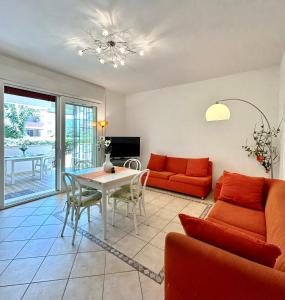 una sala de estar con un sofá y una mesa en Nura's - Casa Flor Seaside, en Alghero