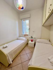 Dos camas en una habitación con ventana. en Nura's - Casa Flor Seaside, en Alghero 16 fotos más