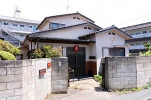 a white house with a gate and a wall at Kinoie guesthouse 3rd buildingーVacation STAY 26705v in Mito