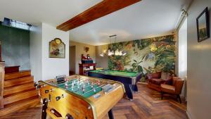 un salon avec un billard et une fresque murale. dans l'établissement Cornillières Maisonnettes 35 pers jacuzzi, jeux, à Tessy-sur-Vire