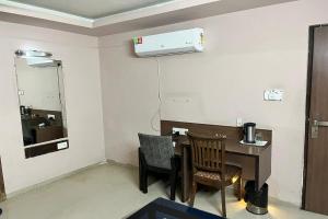 een kamer met een bureau, 2 stoelen en verwarming bij HOTEL SHAILLY INN in Ahmedabad