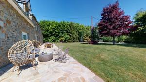 un patio avec deux chaises et une table dans une cour dans l'établissement Cornillières Maisonnettes 35 pers jacuzzi, jeux, à Tessy-sur-Vire