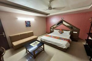 ein Schlafzimmer mit einem großen Bett und einem Sofa in der Unterkunft HOTEL SHAILLY INN in Ahmedabad