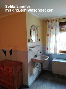 a bathroom with a sink and a mirror and a tub at Ferienwohnung Katharina I in Alf
