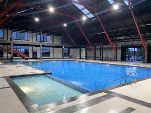 ein großes Schwimmbad in einem großen Gebäude in der Unterkunft tt Residence in Chachoengsao