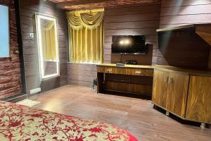 een slaapkamer met een bed en een televisie in een kamer bij HOTEL SHAILLY INN in Ahmedabad