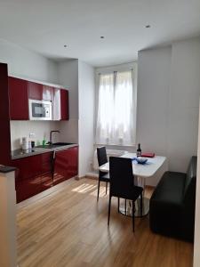 Una cocina y una sala de estar con mesa y sillas. en La Perla del Porto Antico, en Génova