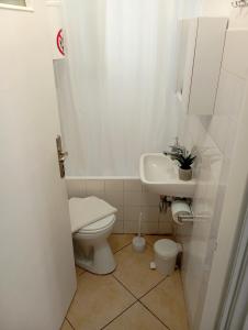 uma casa de banho branca com um WC e um lavatório em La casa di Maria em Atenas