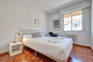 Un dormitorio con una gran cama blanca y una ventana en Camino Pamplona 5 by Clabao, en Pamplona