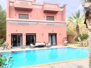 a house with a swimming pool in front of a building at Splendide Villa, Marrakech in Marrakesh