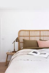 a bed with a book and a lamp on a table at Tingum in Lennox Head