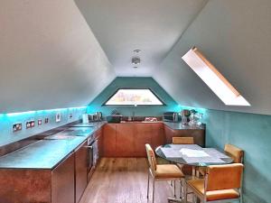 uma pequena cozinha com uma mesa e uma janela em Chy Glynn. Luxury lodge with hot tub and views. em St. Agnes