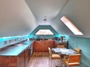 a small kitchen with a table and a window at Chy Glynn. Luxury lodge with hot tub and views. in St. Agnes 