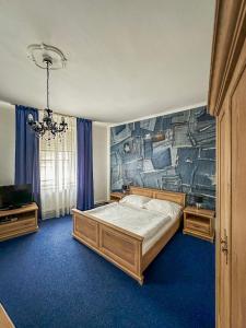 1 dormitorio con 1 cama y un mural en la pared en Hotel Růžek en Hranice