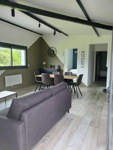 un salon avec un canapé, des chaises et une table dans l'établissement L'ATELIER 5 couchages, à Malville 3 autres photos