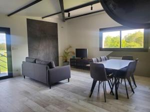 a living room with a table and chairs and a couch at L'ATELIER 5 couchages avec climatisation in Malville