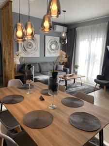 a wooden table with chairs and a living room at Ninemia luxury apartments in Xylokastron