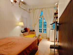 um quarto com uma cama, um sofá e uma janela em Cozy Fun Homestay 16 em Hanói