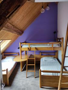 a room with two bunk beds and a purple wall at Gîte de la Peyrouse in Saint-Jean-de-Vaux