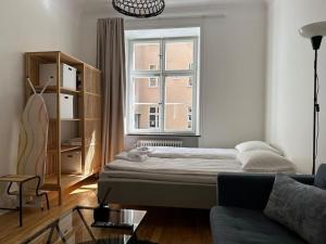 a living room with a bed and a window at Stay Inn Luxury Apartments Ostermalm in Stockholm