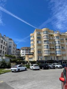 a parking lot with cars parked in front of a building at Ostende Beach View apartment in Castro-Urdiales