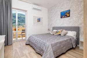 une chambre avec un lit et un balcon dans l'établissement Nonno Angelo - 4 Bedrooms with Free Parking & Seaview Balcony, à Sorrente