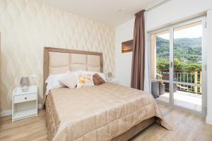 une chambre avec un grand lit et un balcon dans l'établissement Nonno Angelo - 4 Bedrooms with Free Parking & Seaview Balcony, à Sorrente