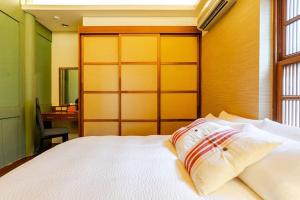 a bedroom with a white bed with a wooden headboard at 臺窩灣Tayouan Villa2024全新房間設備包棟不分租,4房6衛4床2廳1廚房,安平古堡老街走路1分鐘,花園夜市15分 in Anping