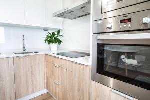 a kitchen with a stainless steel oven and wooden cabinets at Vila Arousa in Vilagarcia de Arousa