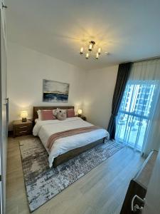 een slaapkamer met een bed en een groot raam bij Yas Island 1br By Skyhomes in Abu Dhabi