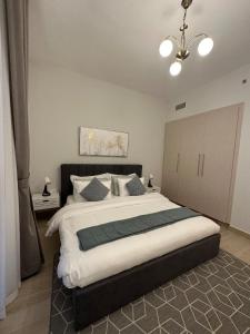 um quarto com uma cama grande e um lustre em Partial Canal View 1br Apartment Yas Island em Abu Dhabi