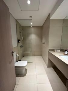 uma casa de banho com um WC, um chuveiro e um lavatório. em Partial Canal View 1br Apartment Yas Island em Abu Dhabi