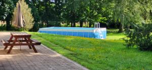 a park with a bench and an umbrella and a pool at Prince des carrés in Saint-Malo-en-Douziois