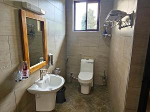 a bathroom with a sink and a toilet and a window at Medan Hotel in Ngateu