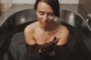 a woman holding a chicken in a bath tub at Spa & Wellness Hotel Silva in Mariánské Lázně
