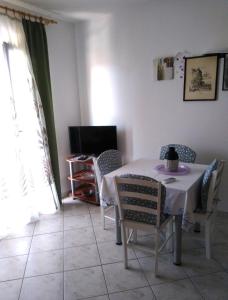a dining room with a table and chairs and a television at Ivago Apartments Sabunike in Privlaka