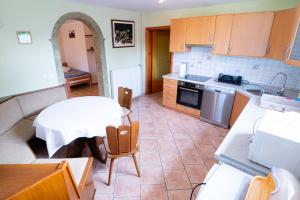 une cuisine avec une table blanche et une table et des chaises dans l'établissement APARTMA JAKOPIČ, à Zgornje Gorje